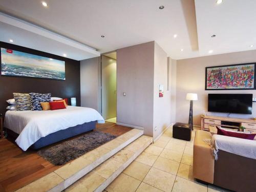约翰内斯堡1007-Stunning Studio apt with incredible Joburg views的一间卧室配有一张床和一台平面电视