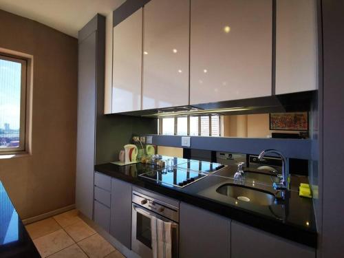 约翰内斯堡1007-Stunning Studio apt with incredible Joburg views的厨房配有水槽和台面