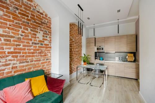 弗罗茨瓦夫Apartament Rynek的一间设有砖墙和绿色沙发的客厅