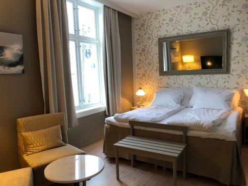 里瑟尔里瑟尔酒店的一间卧室配有一张带镜子和椅子的床