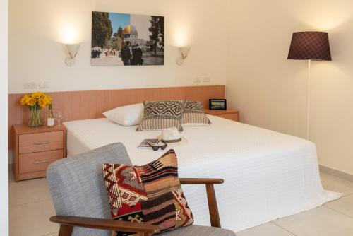 耶路撒冷Austrian Pilgrim Hospice的一间卧室配有一张床和一把带枕头的椅子