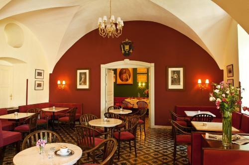 耶路撒冷Austrian Pilgrim Hospice的餐厅拥有红色的墙壁和桌椅