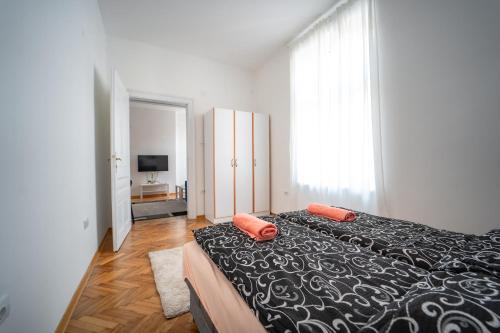 贝尔格莱德Botanical9, Belgrade centre, 2 bedroom apartment的一间卧室配有一张带两个橙色枕头的床