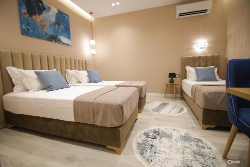 戈里察Vila Livi的一间卧室配有两张床和一张蓝色椅子