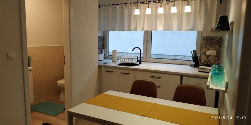 科马罗姆Apartman 3的厨房配有桌子、水槽和窗户