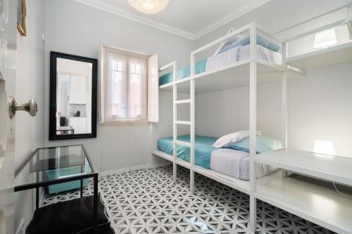 莱里亚Heritage House Leiria的卧室配有白色双层床和镜子