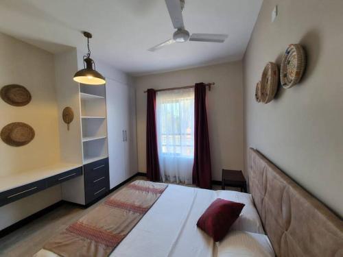 基利菲Elegant 1 Bedroom Condo Near Vipingo Ridge Golf Resort的一间卧室设有一张大床和一个窗户。