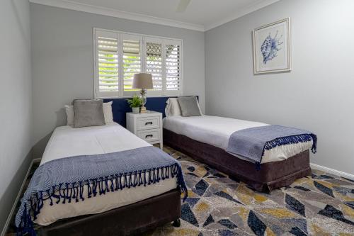 汤斯维尔汤斯维尔南岸公寓的一间卧室设有两张床和窗户。