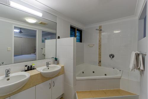 汤斯维尔汤斯维尔南岸公寓的白色的浴室设有2个盥洗盆和1个浴缸。