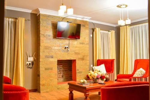 奈瓦沙El Sueno Homestay的客厅设有石制壁炉和红色椅子
