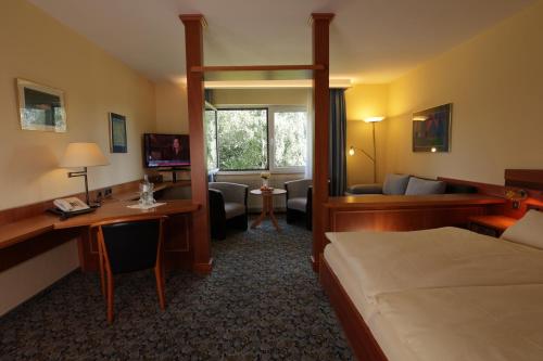 雷姆沙伊德Hotel Restaurant Fischer的配有一张床和一张书桌的酒店客房