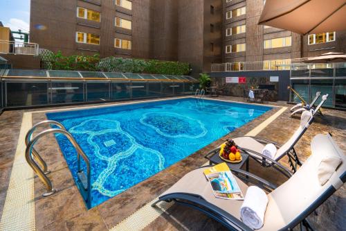 澳门澳门骏龍酒店的一个带椅子的游泳池和一间酒店