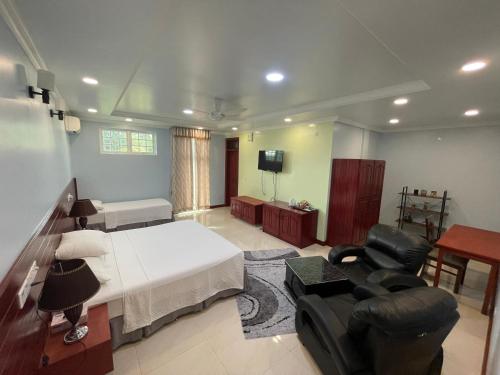 HithadhooVista Villa的一间卧室配有一张床、一张沙发和一台电视。