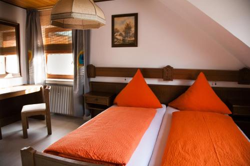 TannHerzog's Ulsterbrücke的卧室配有2个橙色枕头