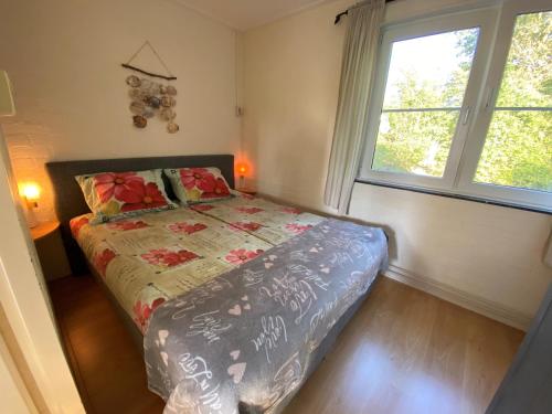 劳雷尔苏格Robbenoort 45的一间卧室设有一张床和两个窗户。