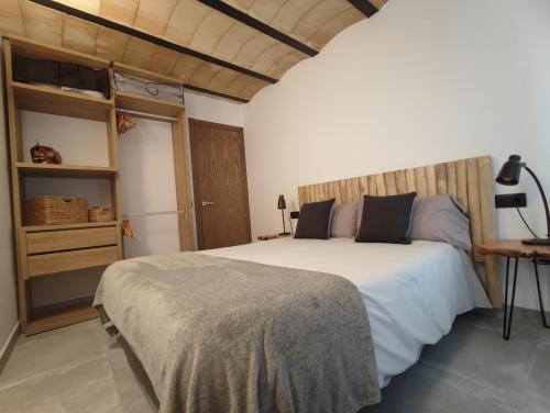 坎普罗东Can Triadú的卧室配有一张白色大床和木制床头板