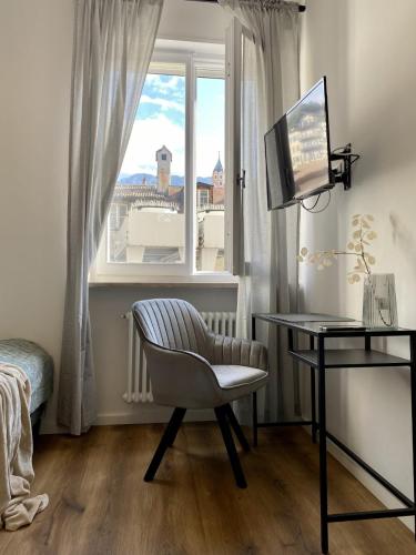 梅拉诺Galilei Apartment的一间卧室配有桌子、椅子和窗户