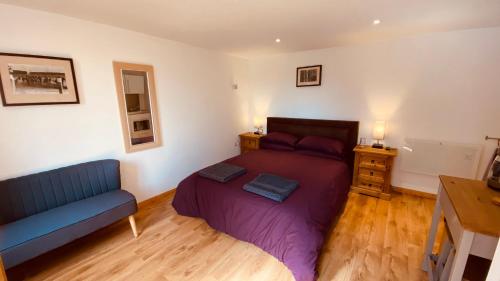IslehamPrivate Detached Annex in Isleham Village的一间卧室配有一张床和一张蓝色的沙发