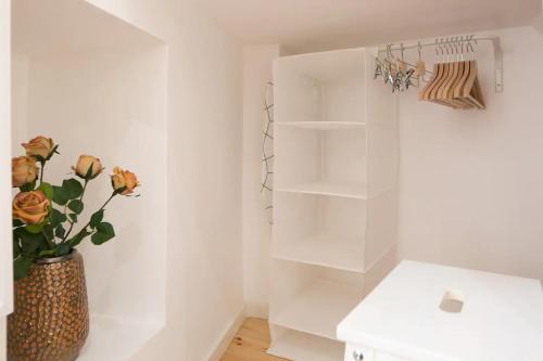 里斯本Central Studio的浴室设有白色的墙壁和植物花瓶