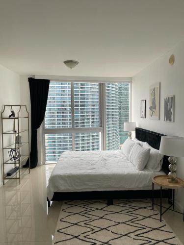 迈阿密IconBrickell Tower 3 W Residences的卧室设有白色的床和大窗户