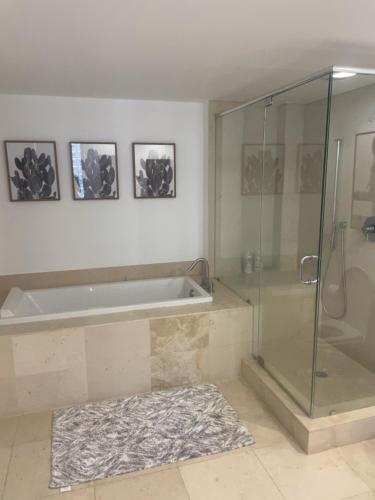 迈阿密IconBrickell Tower 3 W Residences的带浴缸和玻璃淋浴间的浴室。