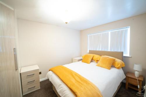 谢菲尔德Longley Farm View -spacious 3 Bed Property的一间卧室配有一张带黄色枕头的床和一扇窗户