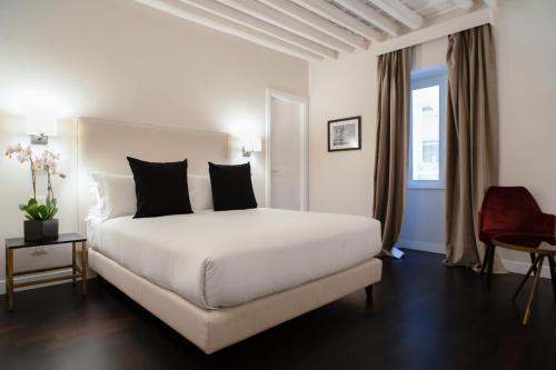 罗马冰砾大厅酒店的卧室配有一张带黑色枕头的大型白色床。