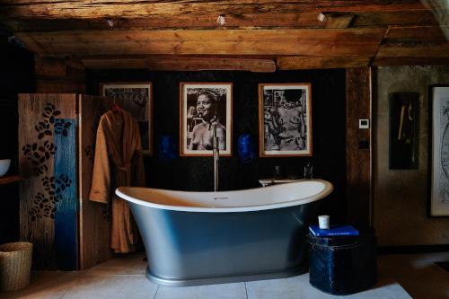 圣莫里斯堡Rustic fireplace hotel comfort Jaccuzi dog friend的墙上挂有照片的房间的浴缸