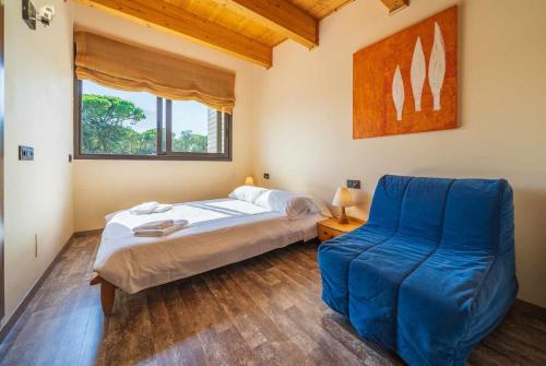 普拉加德阿罗Villa Mestres Playa de Aro的一间卧室配有一张床和一张蓝色椅子