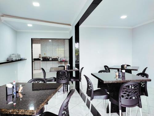 SaloáBarra Nova Hotel的用餐室配有黑色的桌椅