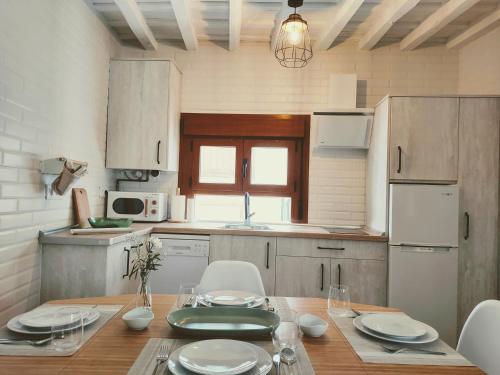 埃尔瓦La casita del olivo的一间带木桌和椅子的厨房以及一间用餐室