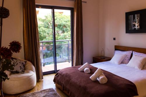 丰沙尔Apartamento Batista by Horizon View Madeira的一间卧室配有一张床、一张沙发和一个窗口
