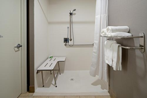 帕姆代尔帕姆代尔兰开斯特假日酒店的带淋浴、桌子和毛巾的浴室
