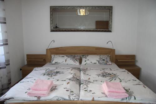 特里尔Gemütliche City Wohnung - Im Herzen von Trier的一间卧室配有一张床,上面有两条粉红色的毛巾