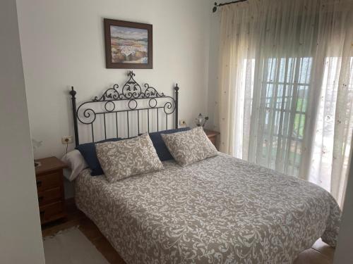 弗龙特拉El Hoyo的一间卧室配有床和带窗帘的窗户