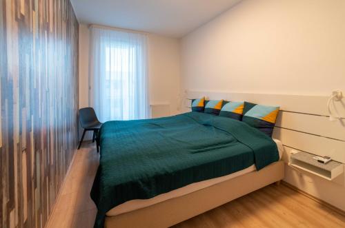 福纽德Balatoni Apartman的一间卧室设有一张绿色的床和一个窗户。