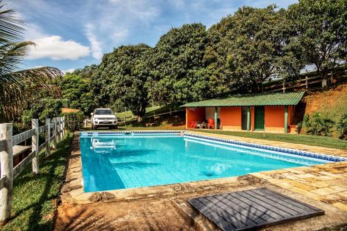 伊加拉塔Chalé das Águas的房屋前的游泳池