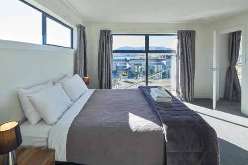 特卡波湖Alpine View Apartment 3 - Tekapo的一间卧室设有一张床和一个大窗户