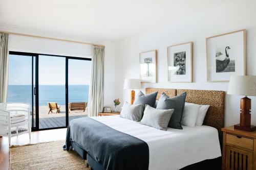 杰林冈海洋农场度假屋的一间卧室设有一张床,享有海景