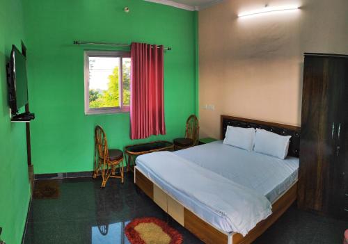 德拉敦Nandini Homestay的一间卧室设有一张床和绿色的墙壁