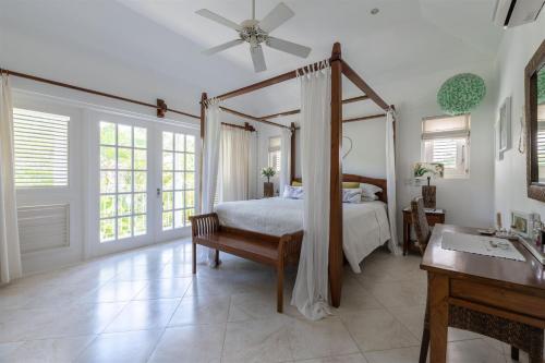 圣彼得教区Shimmers, stunning, stylish West Coast Villa的一间卧室配有天蓬床和水槽