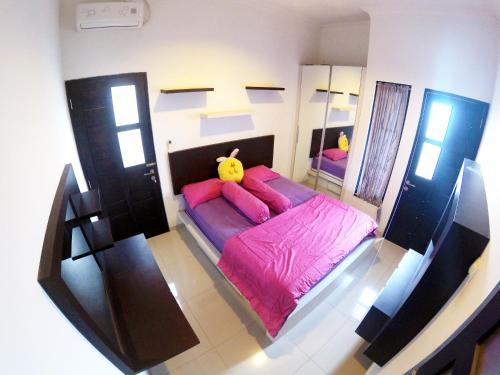 NgabeanGodean Living Homestay Jogja Family only的卧室配有带粉红色枕头的大型粉红色床