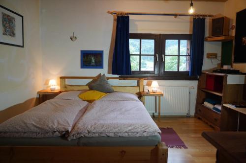 AltlassingWohnstudio in umgebauter Scheune的一间卧室配有一张带两盏灯的床和一扇窗户。