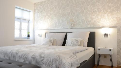 哈尔伯施塔特Rosenwinkel Appartement im OG的卧室配有一张带白色床单的大床和窗户。