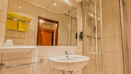 肖林慕勒豪斯海景酒店的白色的浴室设有水槽和淋浴。