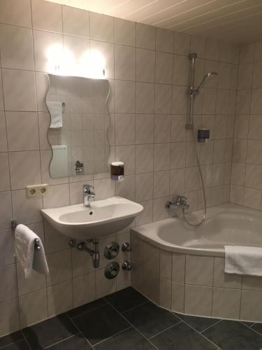 万丹斯Ferienwohnung Thöny Vandans的一间带水槽、浴缸和镜子的浴室