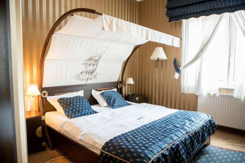 达布罗瓦古尔尼恰苏玛酒店的一间卧室配有一张带蓝色枕头的天蓬床