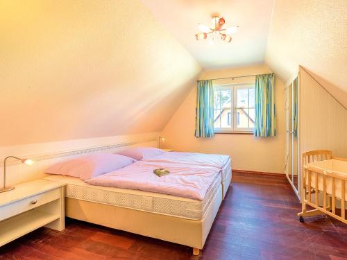 ZirchowReetdachhaus mit Sauna, Kamin & Terrasse - D 028.032的一间卧室配有一张床、一张书桌和一个窗户。