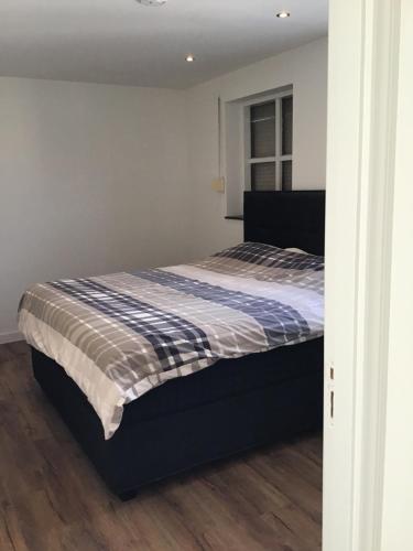 萨斯范亨特Chic appartement in Sas van Gent的一间卧室配有一张带蓝色和白色棉被的床