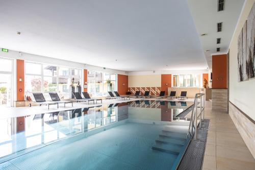 伊姆斯特尊宜斯晨酒店的大楼内带桌椅的大型游泳池